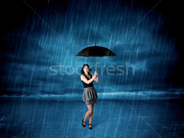 Business woman standing in rain with an umbrella Stock photo © ra2studio