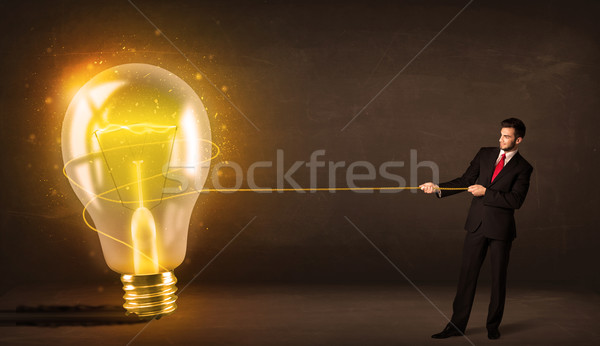 üzletember húz nagy fényes izzó villanykörte Stock fotó © ra2studio
