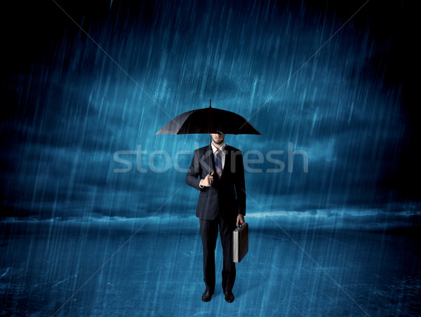 Business man standing in rain with an umbrella Stock photo © ra2studio