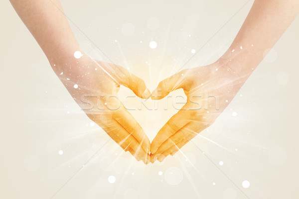 Hands creating a form with yellow shines Stock photo © ra2studio
