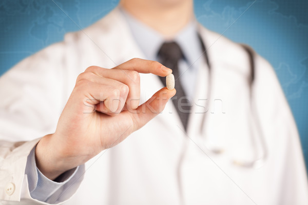 Doctor in white holding a pill Stock photo © ra2studio