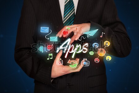 Stock photo: Handsome businessman pressing colorful mobile app icons with bok