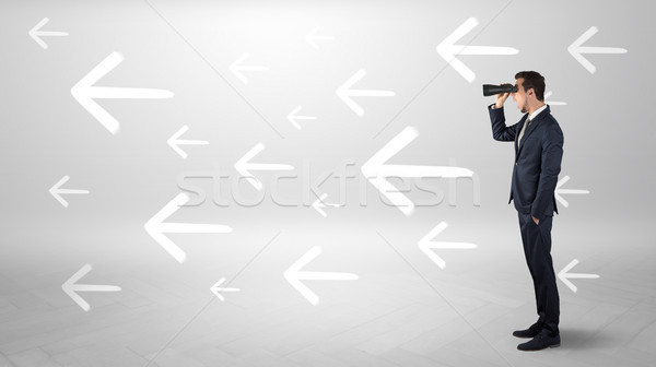 Man looking with binoculars and arrows around Stock photo © ra2studio
