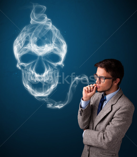 Young man smoking dangerous cigarette with toxic skull smoke Stock photo © ra2studio