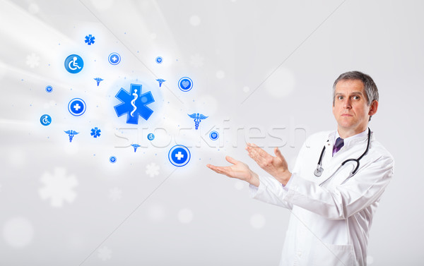 Doctor with blue medical icons Stock photo © ra2studio
