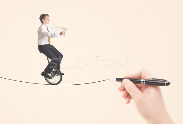 Businessman riding monocycle on a rope drawn by hand Stock photo © ra2studio