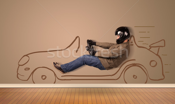 Happy man driving an hand drawn car on the wall Stock photo © ra2studio