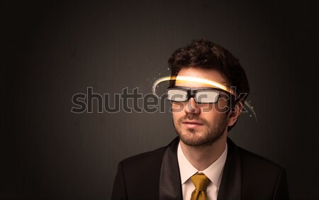 Stock photo: Handsome man looking with futuristic high tech glasses 