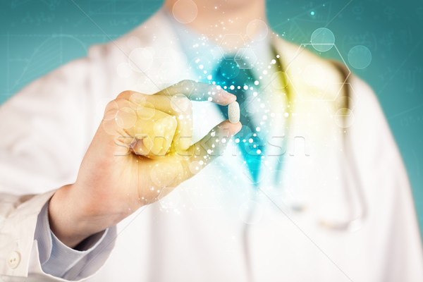 A doctor in tie holding a pill Stock photo © ra2studio