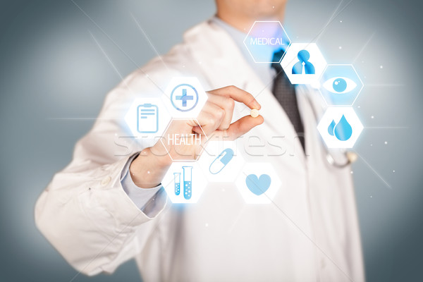 A doctor in white holding a pill Stock photo © ra2studio