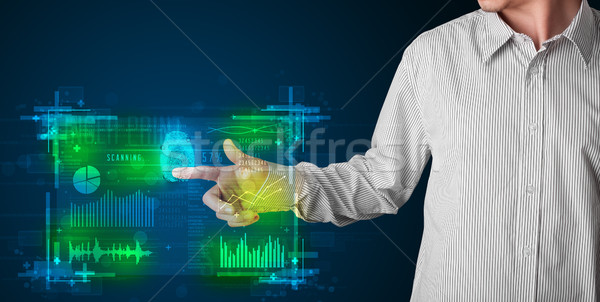 Young businessman pressing modern technology panel with finger p Stock photo © ra2studio