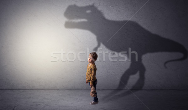 Dinosaurus shadow behind cute boy Stock photo © ra2studio