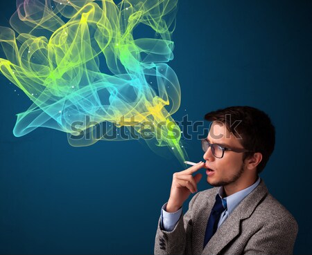 Stock photo: Handsome man smoking cigarette with colorful smoke
