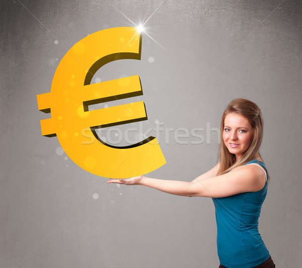 Beautiful girl holding a big 3d gold euro sign Stock photo © ra2studio