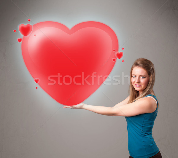 Young lady holding lovely 3d red heart Stock photo © ra2studio
