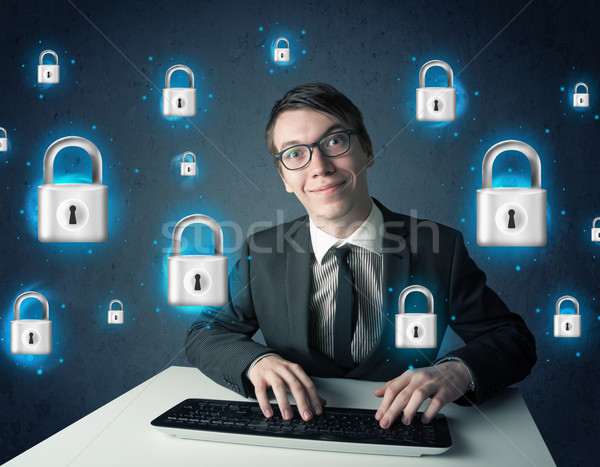 Stock photo: Young hacker with virtual lock symbols and icons