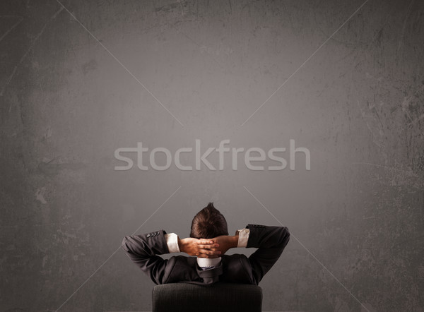 Businessman sitting in front of a wall with copy space Stock photo © ra2studio