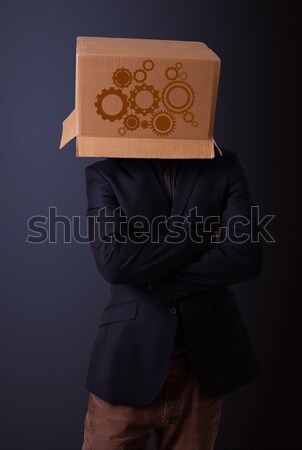 Young man gesturing with a cardboard box on his head with spur w Stock photo © ra2studio