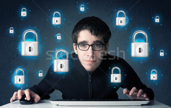 Young hacker with virtual lock symbols and icons Stock photo © ra2studio