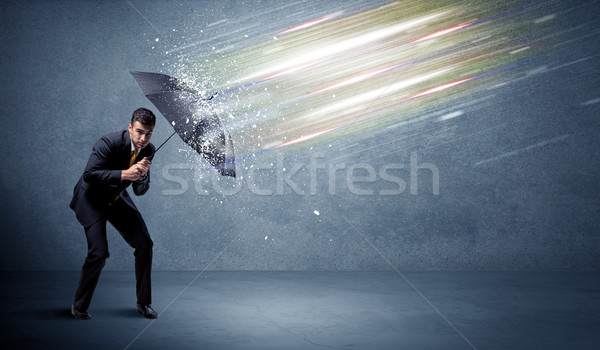 Stock photo: Business man defending light beams with umbrella concept