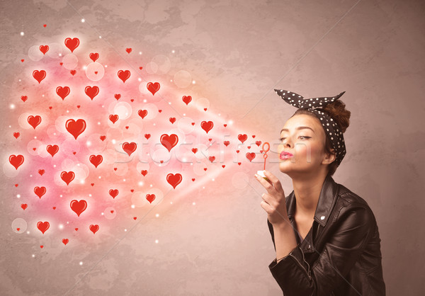 Pretty young girl blowing red heart symbols  Stock photo © ra2studio