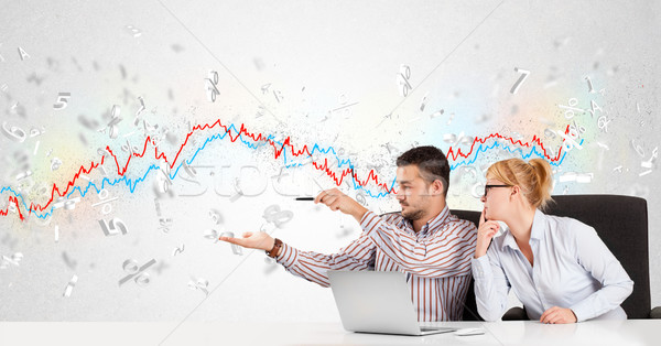 Business man and woman sitting at table with stock market graph  Stock photo © ra2studio
