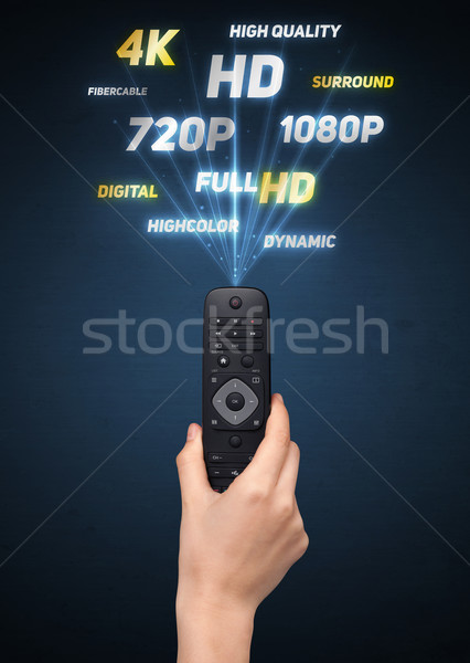 Hand with remote control and multimedia properties Stock photo © ra2studio