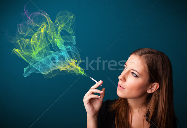 Stock photo: Pretty lady smoking cigarette with colorful smoke
