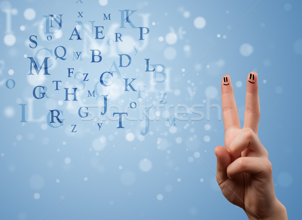 Happy smiley fingers looking at mixture of bokeh letters Stock photo © ra2studio