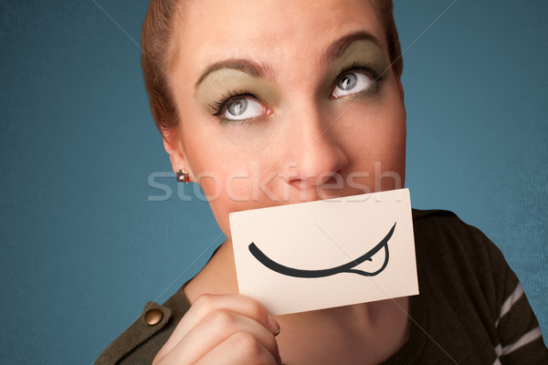 Pretty young girl holding white card with smile drawing  Stock photo © ra2studio