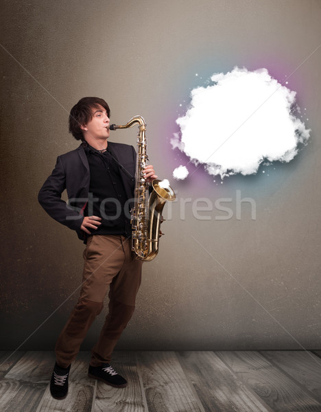 Young man playing on saxophone with copy space in white cloud Stock photo © ra2studio