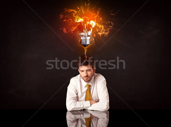 Businessman sitting under a blowing idea bulb Stock photo © ra2studio