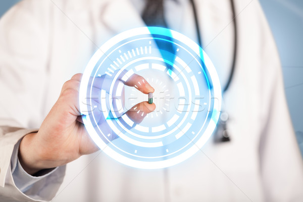 Male doctor holding a pill with glowing circles Stock photo © ra2studio