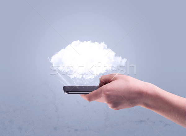 Hand holding phone with empty cloud Stock photo © ra2studio