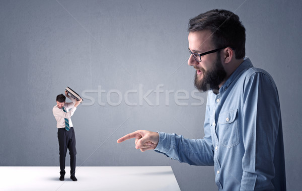 Young businessman fighting with miniature businessman Stock photo © ra2studio