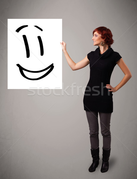 Young woman holding smiley face drawing Stock photo © ra2studio