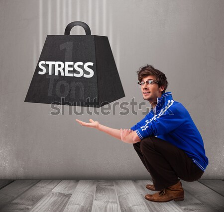 Handsome boy holding one ton of stress weight Stock photo © ra2studio