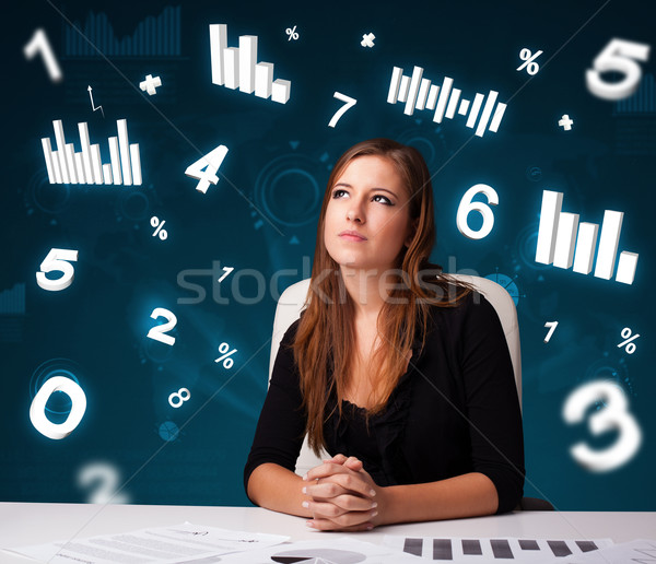 Pretty young businesswoman sitting at desk with diagrams and statistics Stock photo © ra2studio