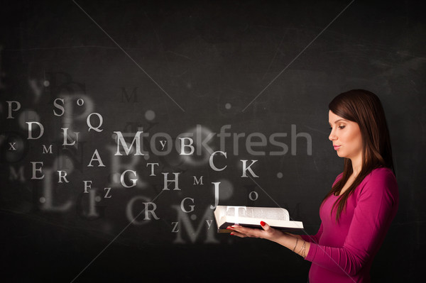 Young lady reading a book with alphabet letters Stock photo © ra2studio
