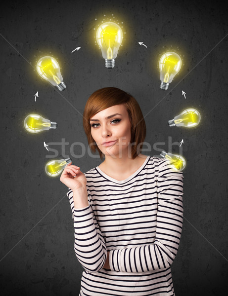 Stock photo: Young woman thinking with lightbulb circulation around her head