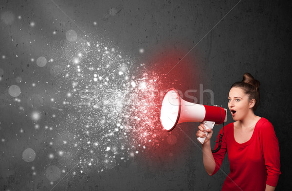 Woman shouting into megaphone and glowing energy particles explo Stock photo © ra2studio