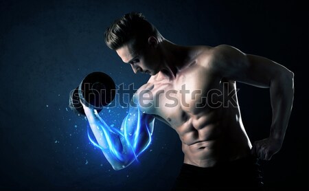 Muscular body builder lifting weight with energy lights on bicep Stock photo © ra2studio