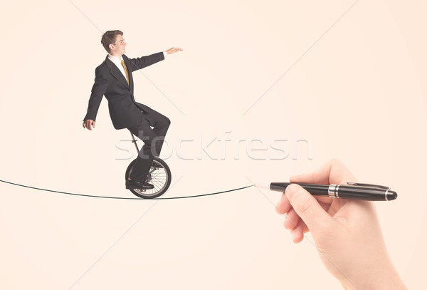 Businessman riding monocycle on a rope drawn by hand Stock photo © ra2studio