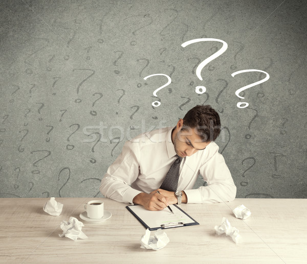 Businessman at desk with question mark Stock photo © ra2studio