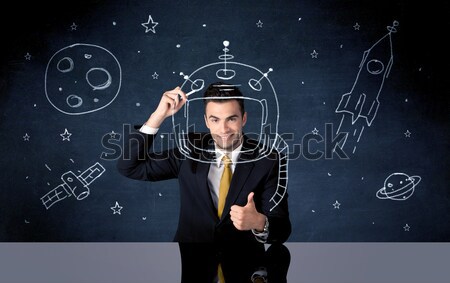 Sales person drawing helmet and space rocket Stock photo © ra2studio