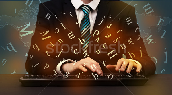 Man typing in formal clothing and letters around Stock photo © ra2studio