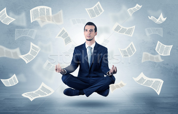 Om de afaceri meditativ care zboară hârtie tineri documente Imagine de stoc © ra2studio