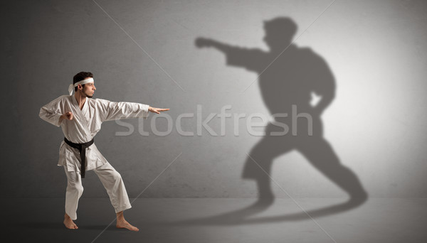 Karate man confronting with his own shadow Stock photo © ra2studio