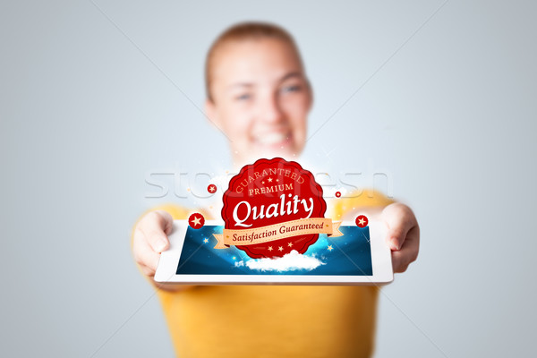 Stock photo: woman holding tablet with red quality label in clouds
