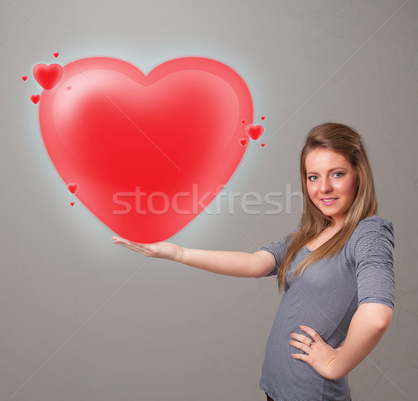 Young lady holding lovely 3d red heart Stock photo © ra2studio